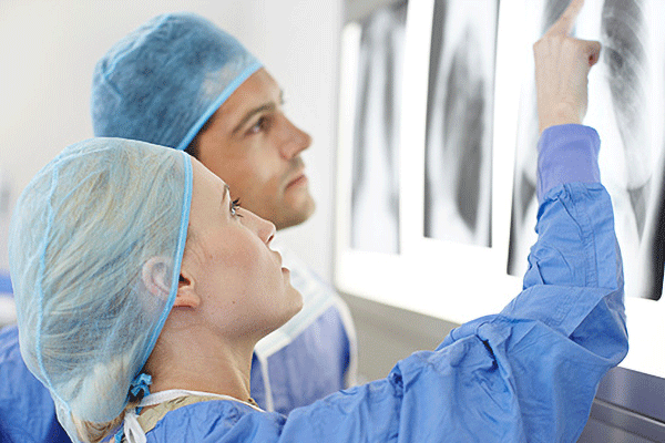 Operating staff examining x-rays of the ribcage and lungs.