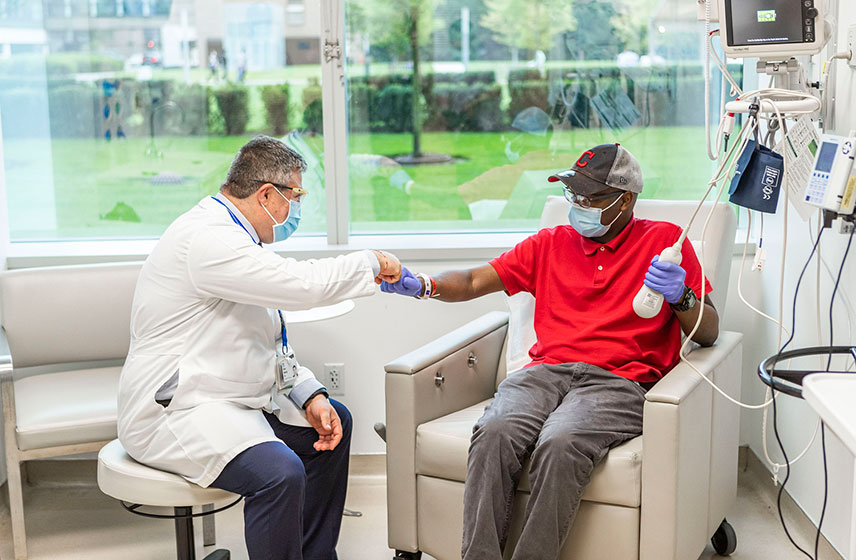 Cleveland Clinic doctor fist bumping an elderly patient receiving treatment.