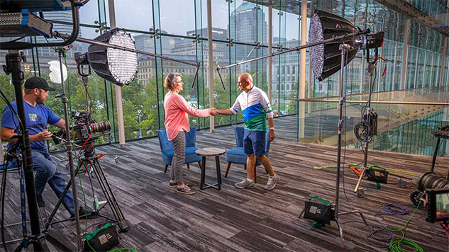 Woman and man shaking hands before sitting down for talk in The Gratitude Sessions.