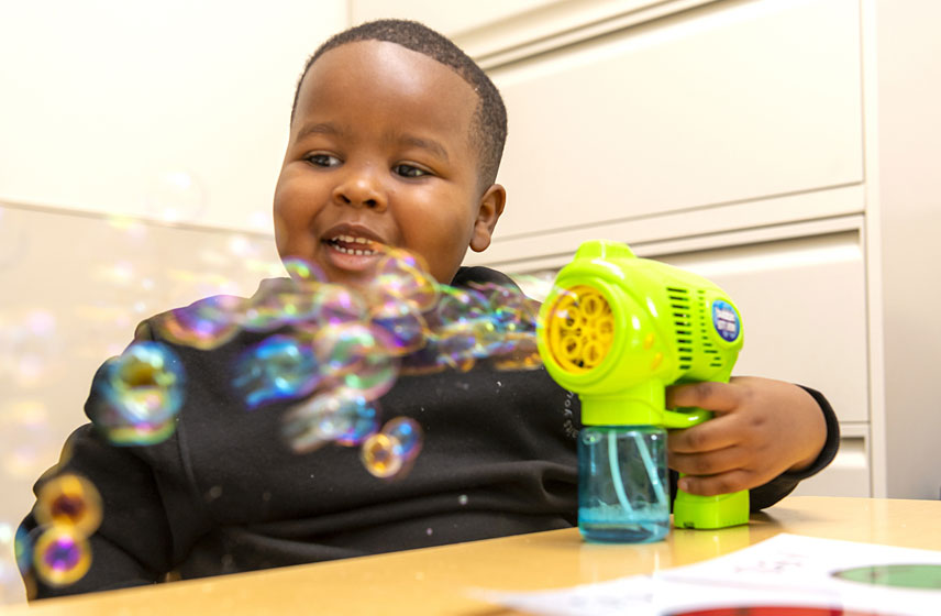 Pediatric patient laughing during physical rehabilitation.