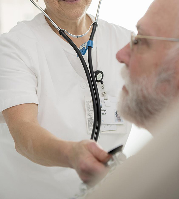 nurse with sthescope on patient's heart