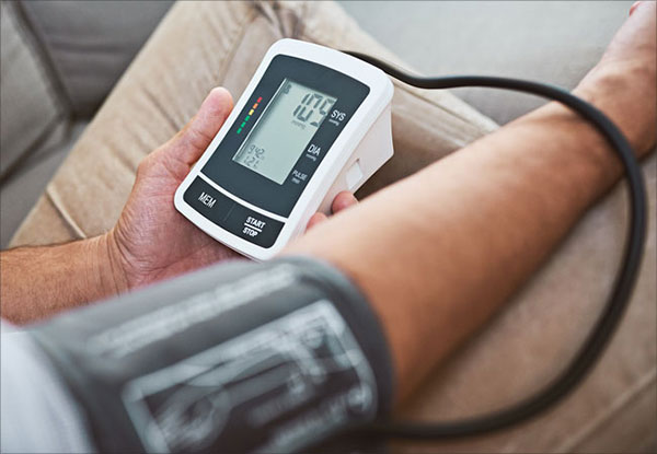 Person using home blood pressure monitor