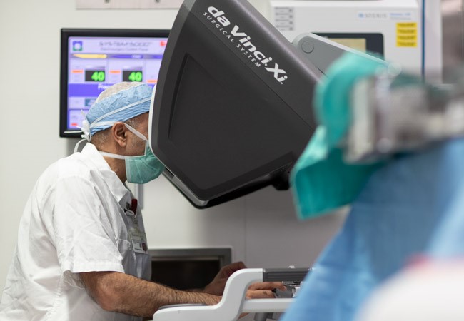 Surgeon sits at robotic surgical console