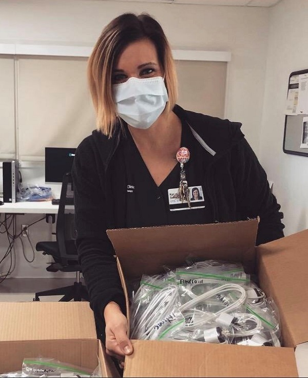 Cleveland Clinic caregiver Karrie Sweeney is shown with phone chargers she collected for patients to use. 