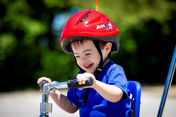Child riding an adaptive tricycle