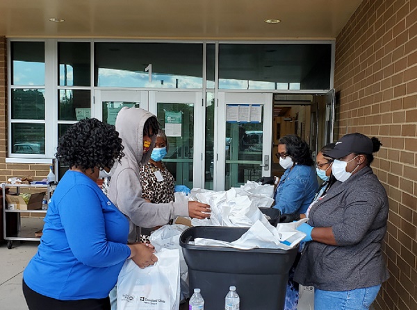 Volunteers distribute COVID-19 care kits at Helen Arnold Community Learning Center