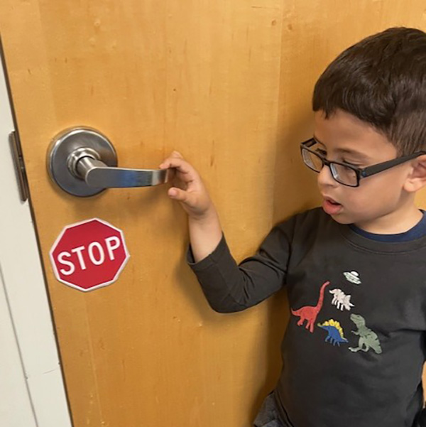 Child with autism looks at warning sign to help stop wandering