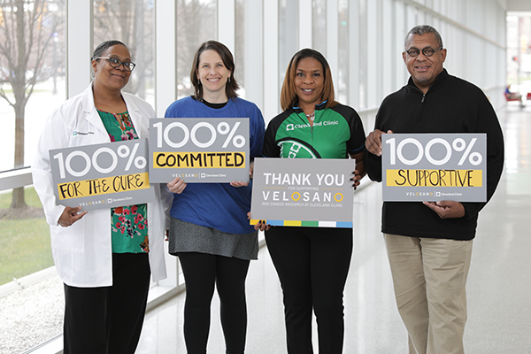 Researchers hold signs thanking donors who have given to VeloSano