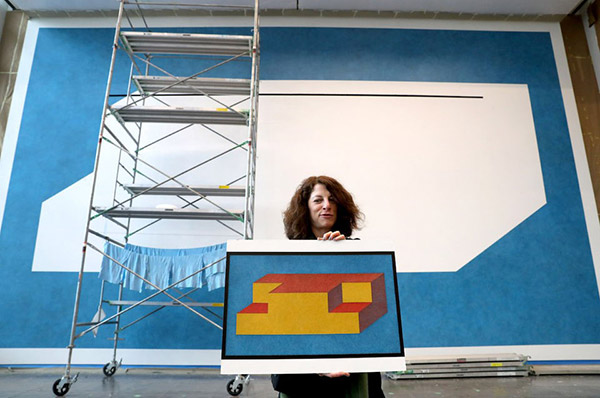 Joanne Cohen, Executive Director of the Cleveland Clinic's Art program, holds Sol LeWitt artwork, to show what the background will represent inside the CWRU-Cleveland Clinic Health Education Campus, Wednesday, February 27, 2019. (Marvin Fong / The Plain Dealer)