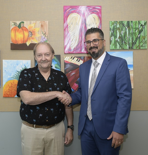 Houssein Abdul Sater, MD, Regional Research Director of the Cleveland Clinic Florida Cancer Institute, shakes the hand of Paul Weiss, the first patient to enroll in the clinical study.