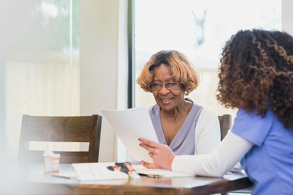 Medical worker assists patient with paperwork in a homecare setting