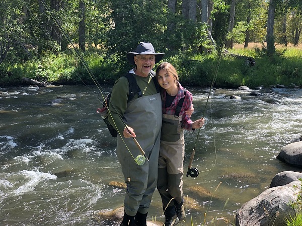 Scott Sumner and his daughter, Michelle, fly-fishing in a river.