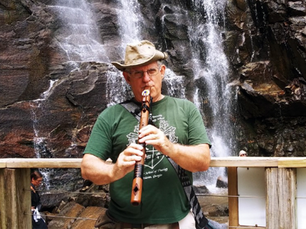 Chaplain Reeves playing his Native American flute at the bottom of Linville Falls in North Carolina.
