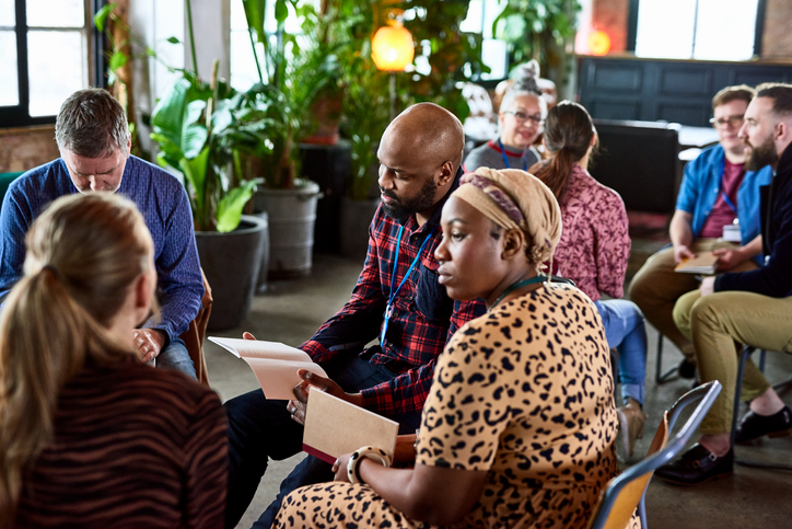 A meeting with people sitting and talking in small groups