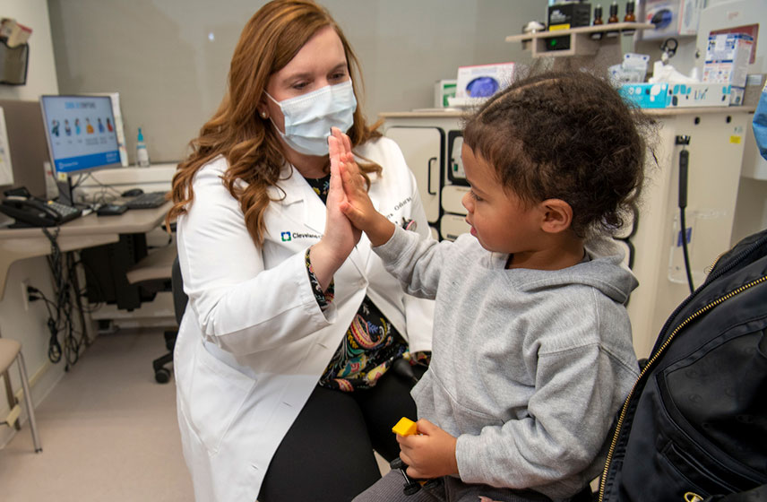 Cleveland Clinic doctor high fiving pediatric patient.