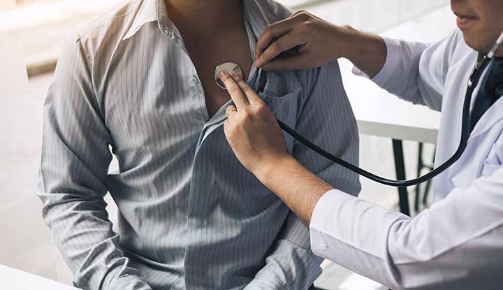 Photograph of a healthcare provider using a stethoscope to listen to someone's heart.