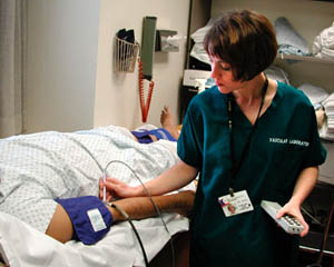A nurse giving a pulse volume recording to a patient.