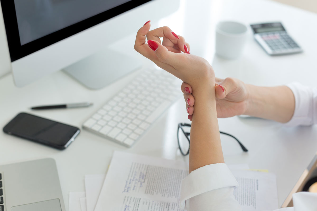 Feminine hand masaging sore wrist.