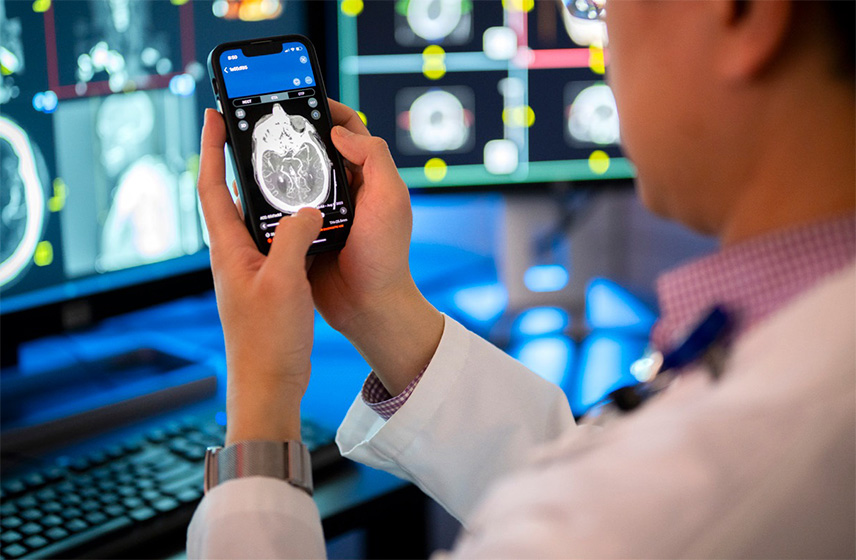 A man holding a mobile device with a stroke detection app on the screen