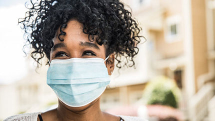 Woman wearing a mask walking down the street