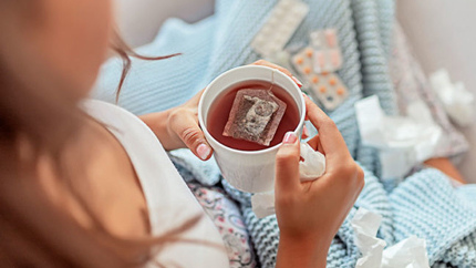 Sick woman with cup of tea