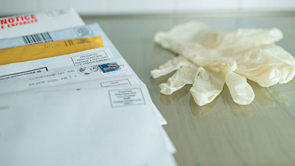 Unopened mail and plastic gloves on the counter