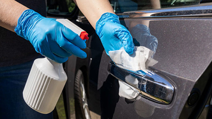 Person cleaning car door handle
