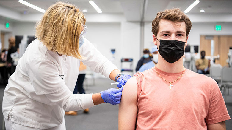 Young man in mask getting vaccine shot