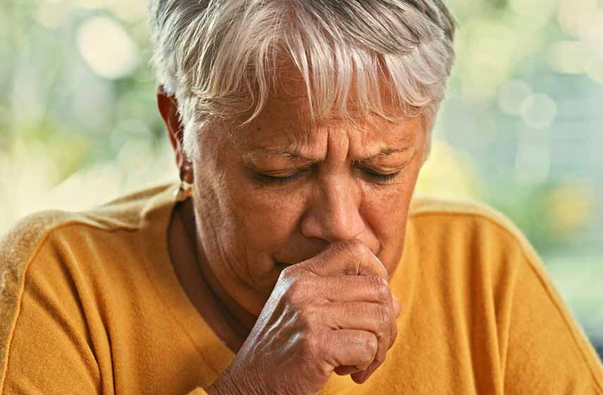 Woman coughing with her hand covering her mouth