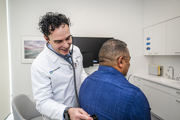 Dr. Costa- Allen listening to stethoscope with patient