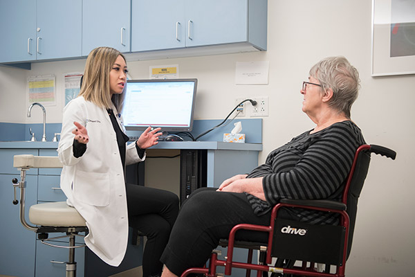 Dr. Nguyen speaks with a patient about her movement disorder.