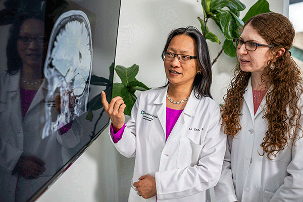 Two doctors examining a scan of the brain for multiple sclerosis.