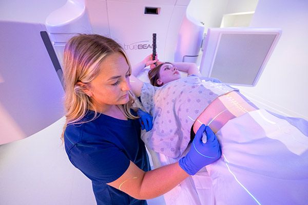 A Cleveland Clinic Caregiver marking where radiation will be administered on a patient.