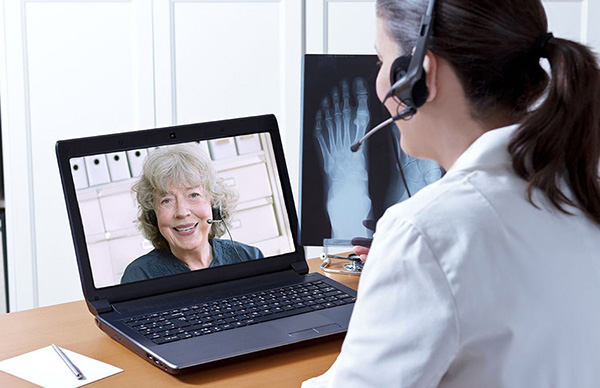 A physician talking with a patient on a computer.
