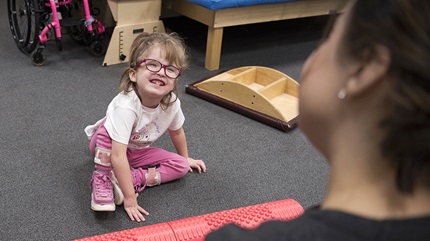 Kaylee smiles up at her physical therapist. (Courtesy: Cleveland Clinic)