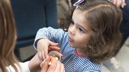 Harper eating cashew butter during one of her test sessions at Cleveland Clinic Food Allergy Center of Excellence. 