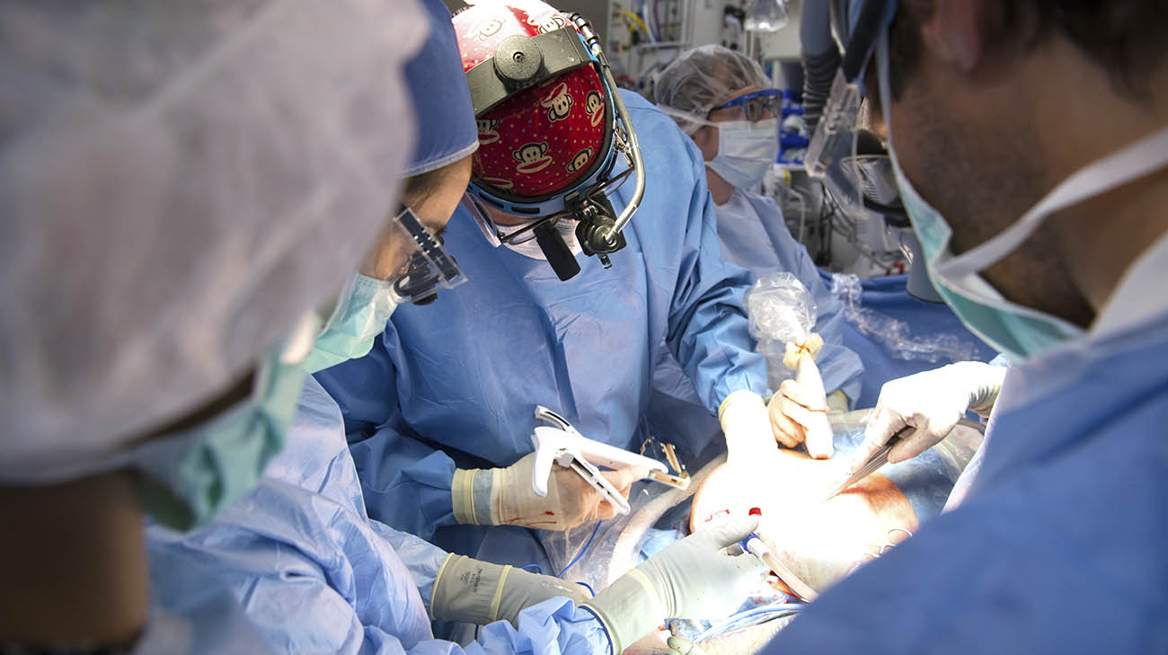  Doctors partially deliver the baby via C-section. While the baby is connected to the umbilical cord, a surgeon opens the baby's chest and removes the mass.