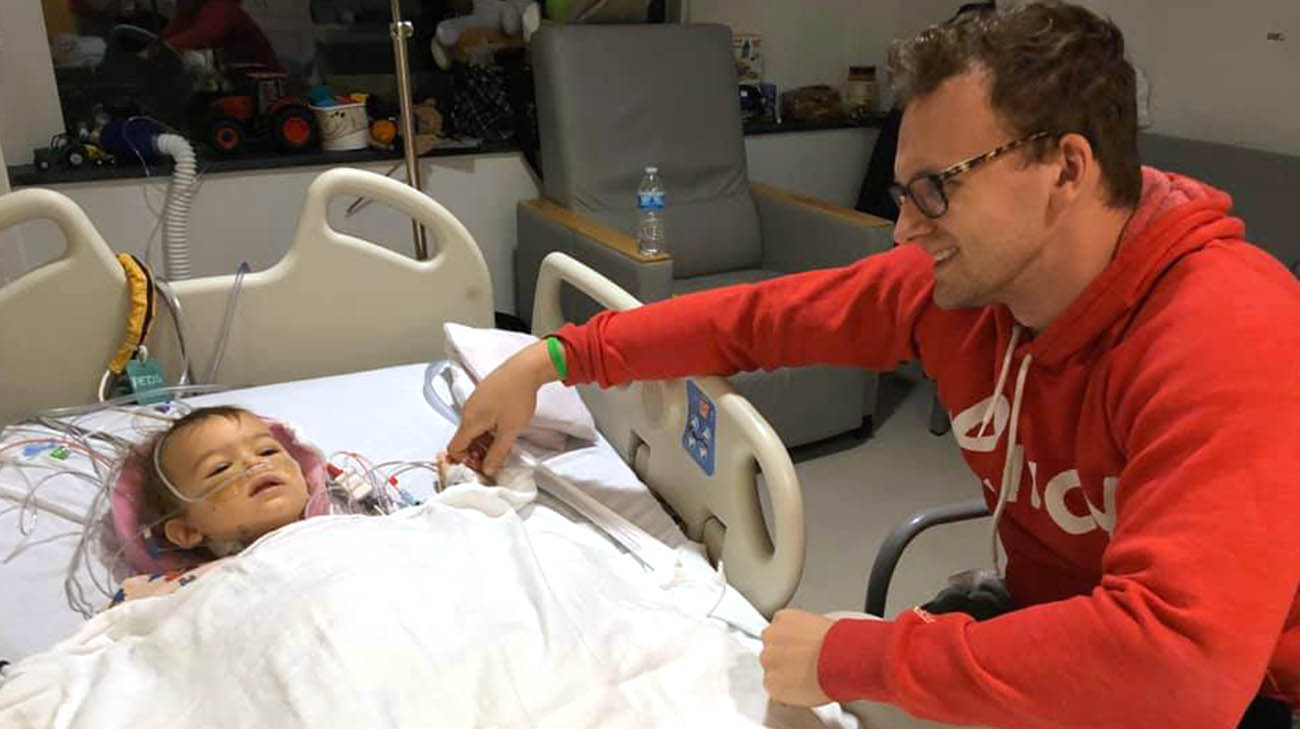 Grant holding his nephew's hand after transplant surgery. 