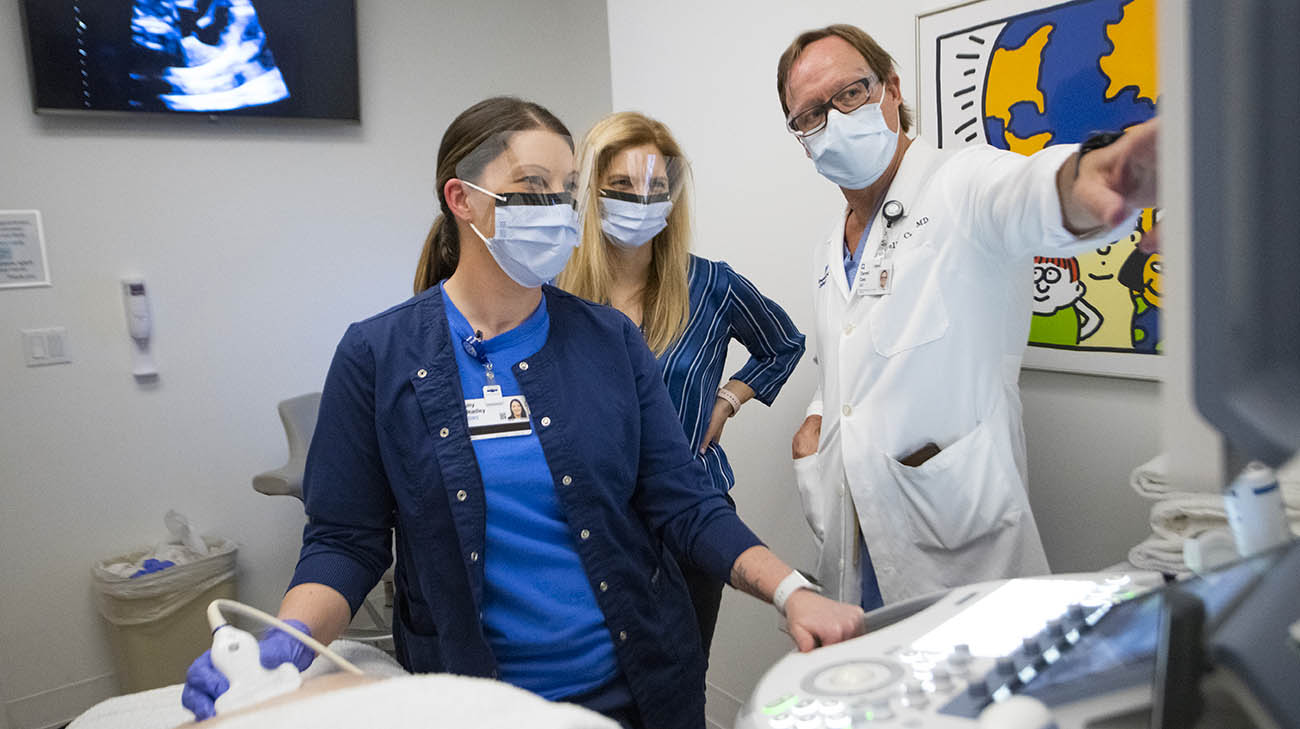 Dr. Darrell Cass and Dr. Amanda Kalan looking at images from a fetal ultrasound. 