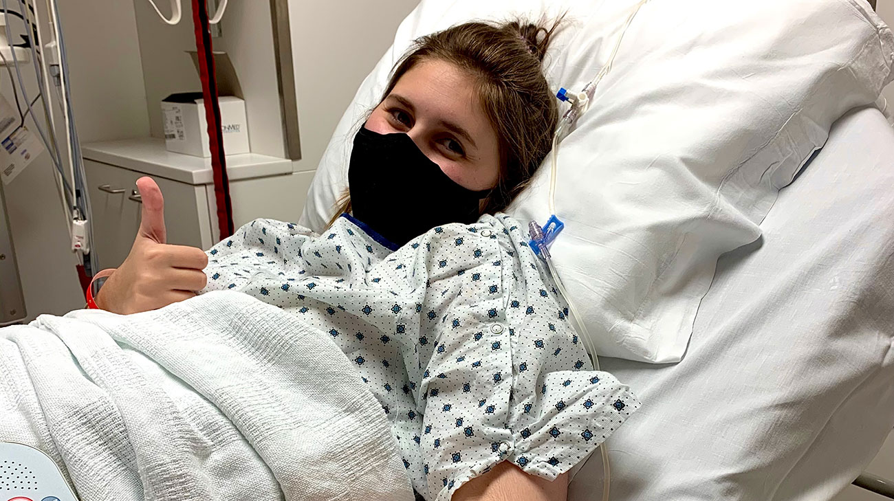 patient giving thumbs up in hospital bed