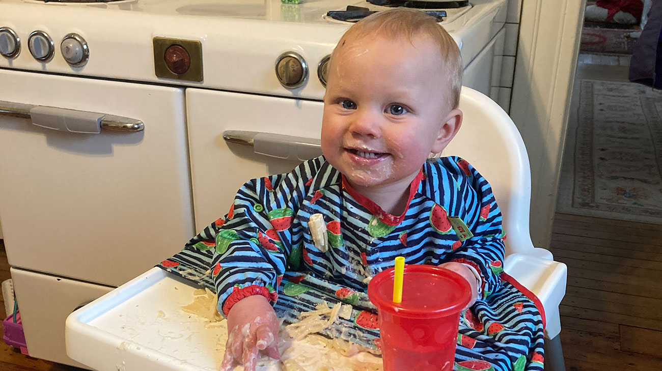 Sitting in her high chair, June Peters is happily eating food without the help of a nasogastric tube.