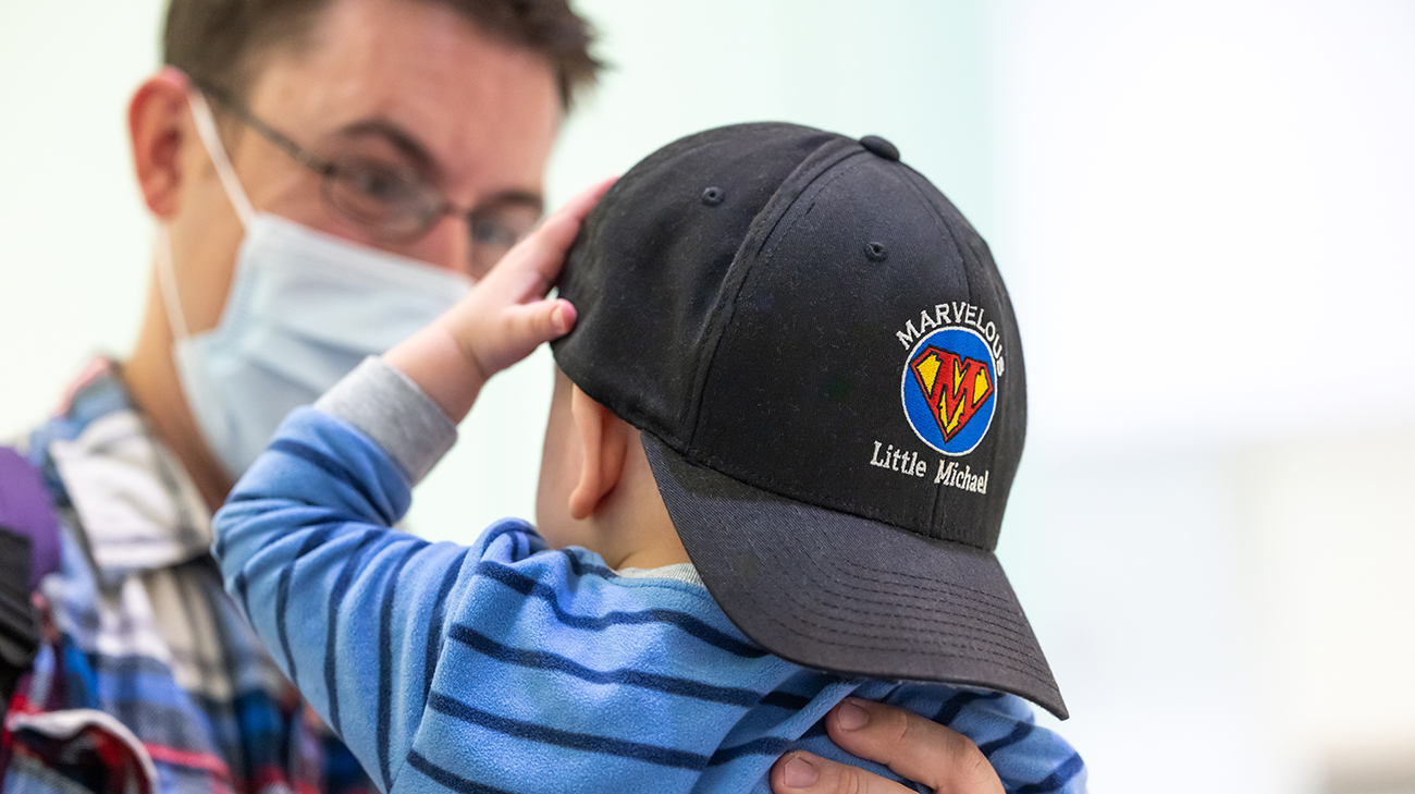 Mikey wearing a hat that says, 'marvelous little Michael.'