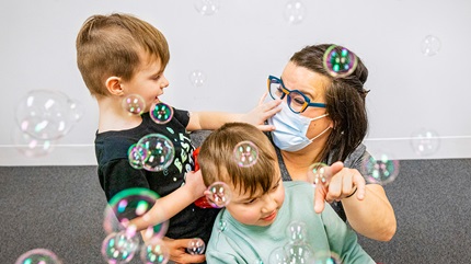 Oliver and Johnny with their mom, Jackie, playing with bubbles.