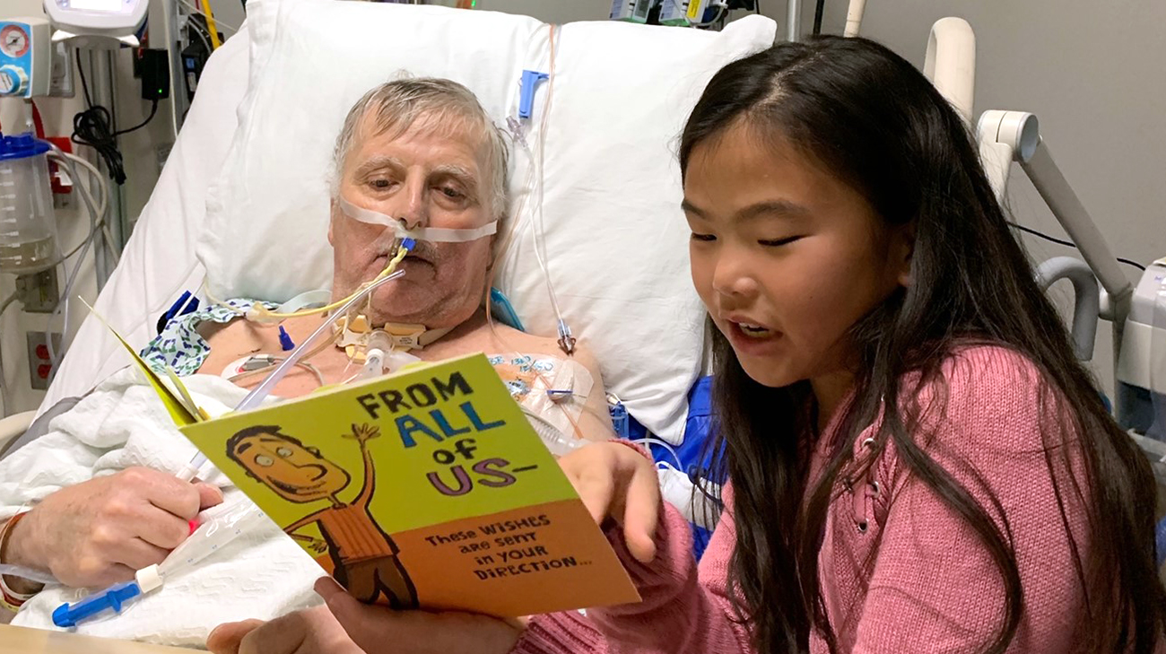 Sabine reading a book to Geoff while he was hospitalized at Cleveland Clinic. 