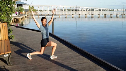 Stephanie smiling as she does her stretches before a run.