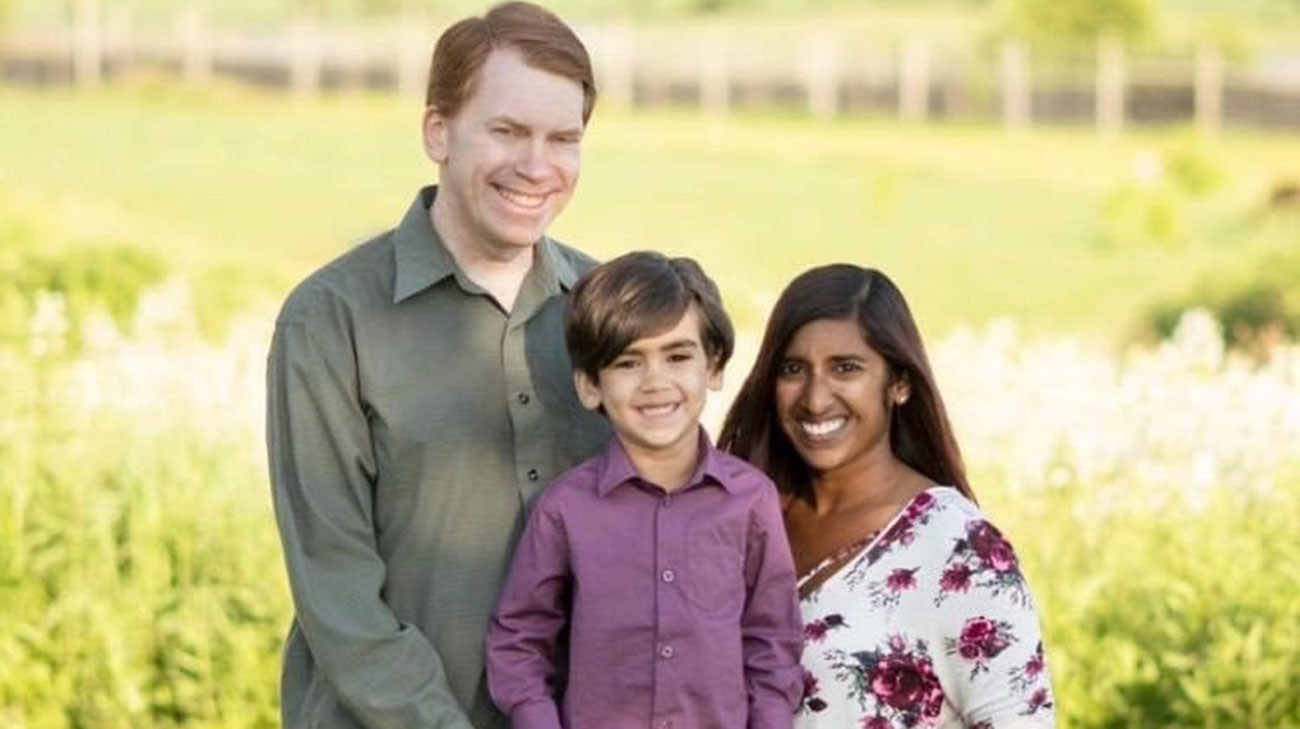 Emily standing with her family.