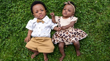 Portrait of Kimyah and DJ lying in the grass.