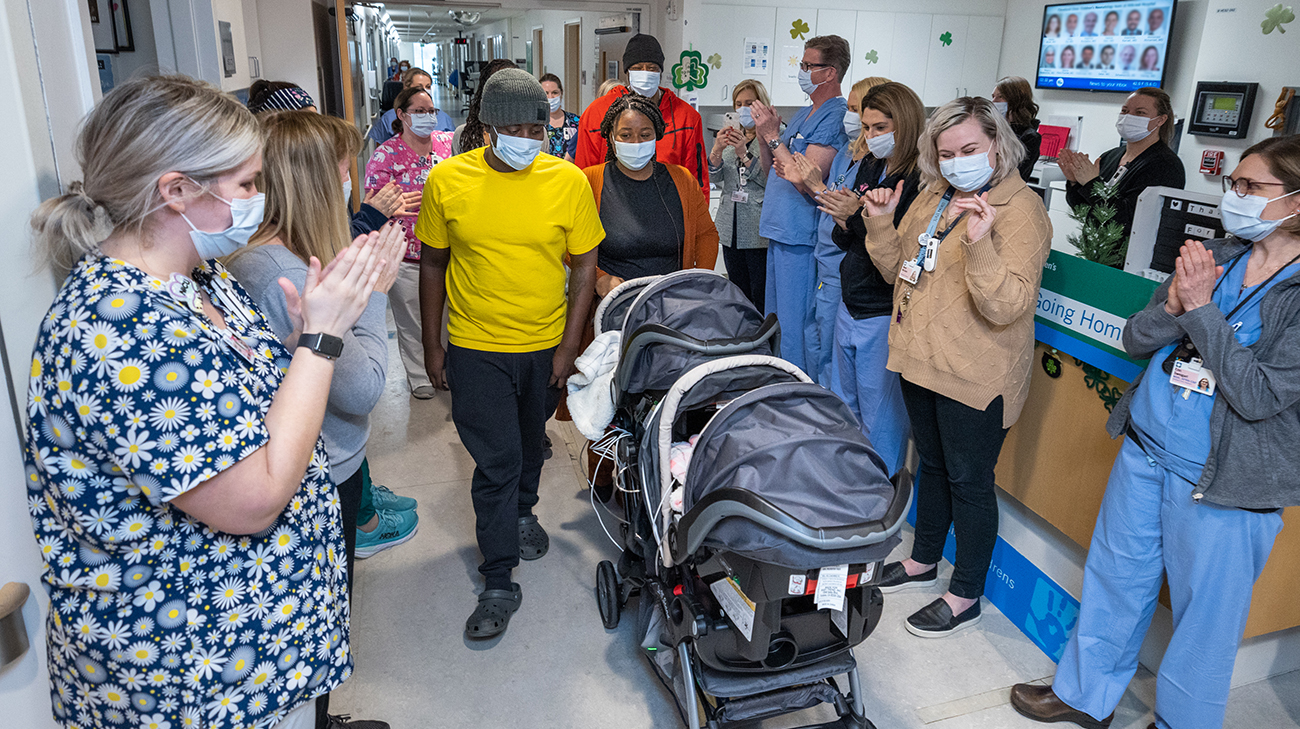 Kimyah and DJ's care team clapping as they leave the hospital to go home for the first time.