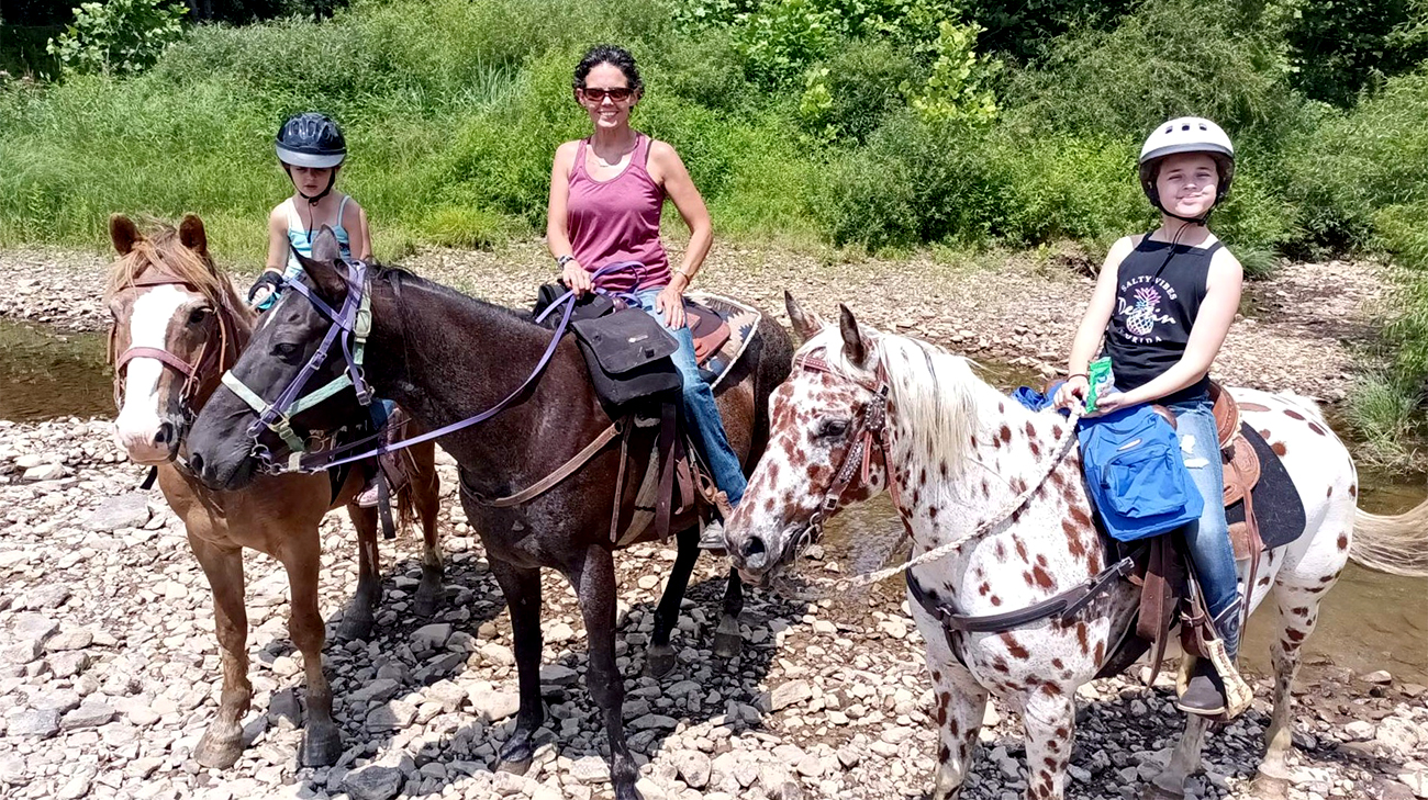 Nicole and her daughters riding horses. 