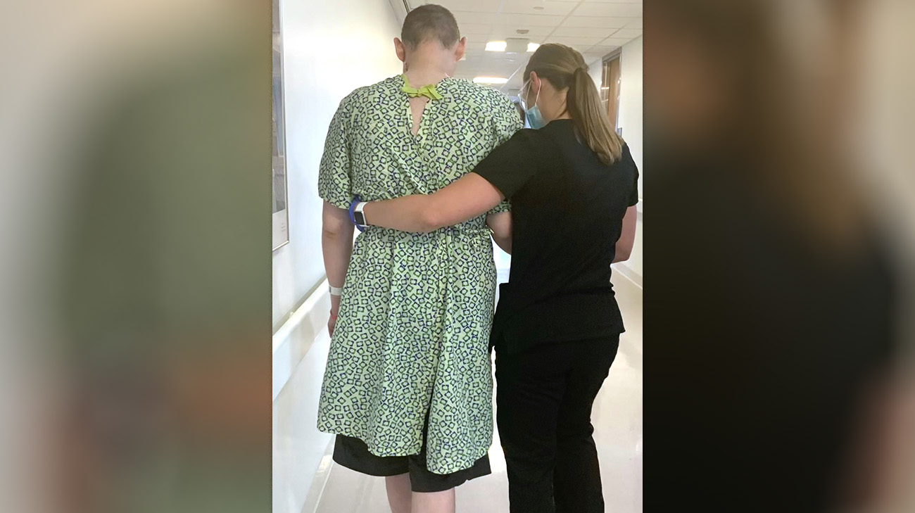 Aaron walking the halls with his physical therapist at Cleveland Clinic, after undergoing reconstructive surgery. 